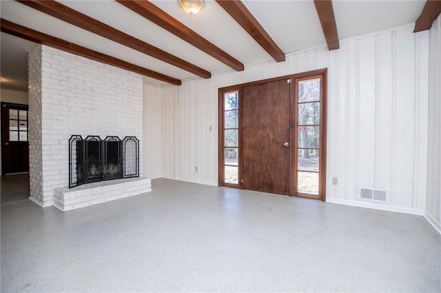 unfurnished living room featuring beam ceiling and a brick fireplace