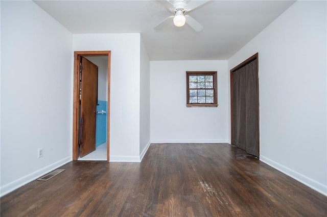 empty room with dark hardwood / wood-style flooring and ceiling fan