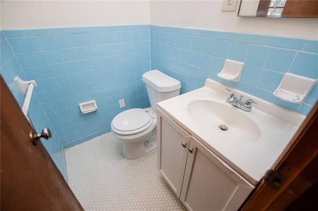 bathroom with vanity, tile walls, tile patterned floors, and toilet