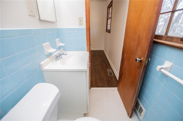 bathroom featuring vanity and tile walls