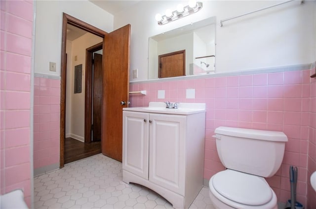 bathroom featuring tile walls, vanity, tile patterned floors, and toilet