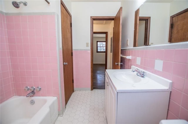 bathroom featuring tiled shower / bath, vanity, tile patterned flooring, and tile walls