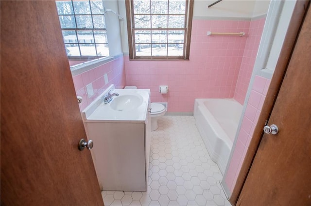 full bathroom with toilet, shower with separate bathtub, tile walls, vanity, and tile patterned flooring