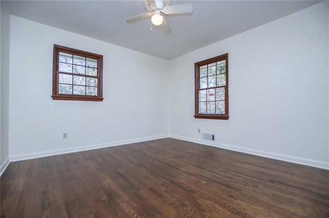 empty room with dark wood-type flooring and ceiling fan