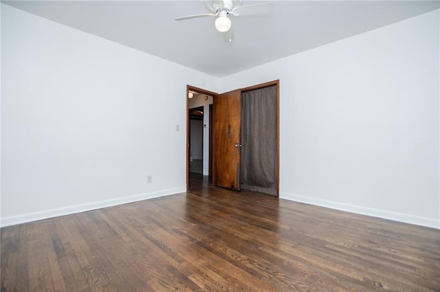 empty room with dark wood-type flooring and ceiling fan