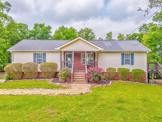 ranch-style house featuring a porch, roof with shingles, stairs, and a front lawn