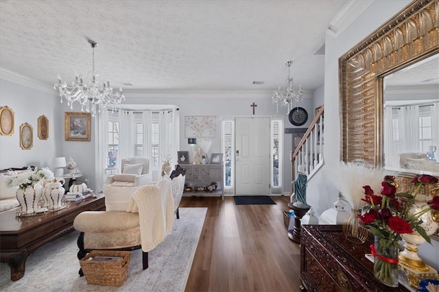 living area with a chandelier, ornamental molding, stairway, and dark wood-style floors