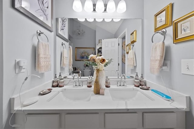 full bathroom featuring lofted ceiling, double vanity, and a sink