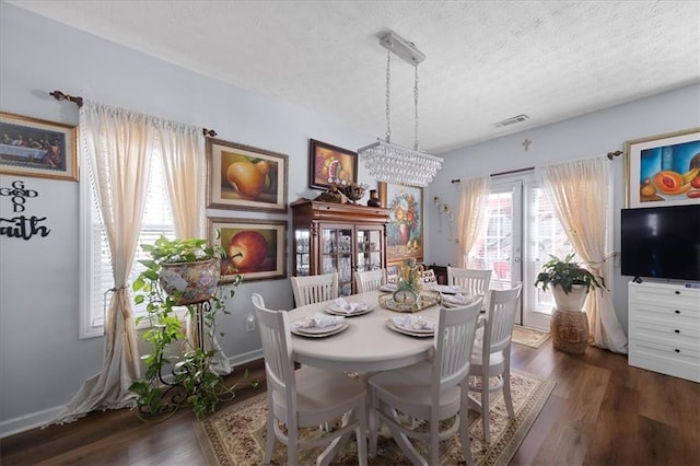 dining area featuring baseboards, a textured ceiling, visible vents, and dark wood-style flooring