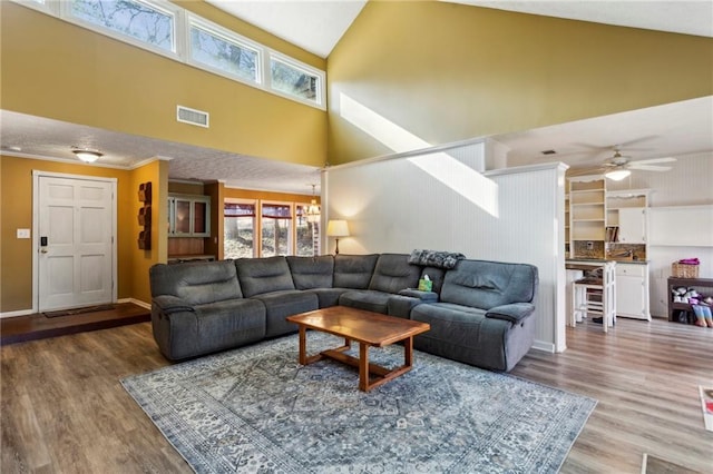 living room featuring high vaulted ceiling, plenty of natural light, and hardwood / wood-style floors