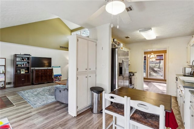 kitchen with white cabinetry, stainless steel appliances, light hardwood / wood-style flooring, and plenty of natural light