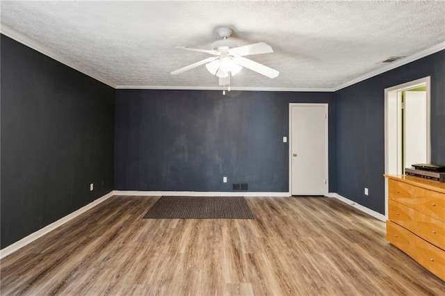 spare room featuring ornamental molding, hardwood / wood-style floors, and a textured ceiling