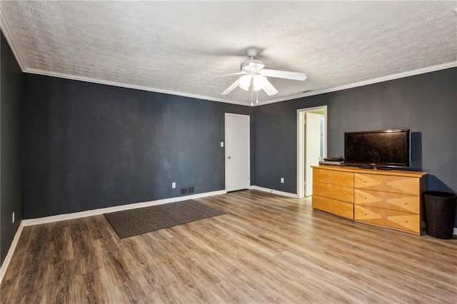 unfurnished bedroom featuring ceiling fan, hardwood / wood-style flooring, ornamental molding, and a textured ceiling