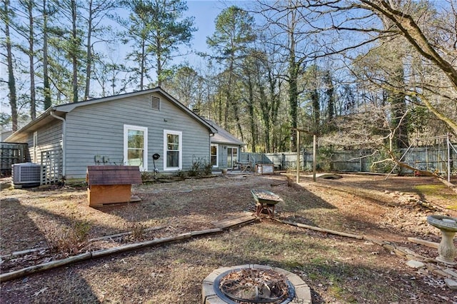 rear view of house featuring cooling unit and a fire pit