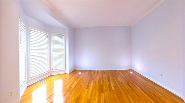 spare room featuring crown molding and light wood-type flooring