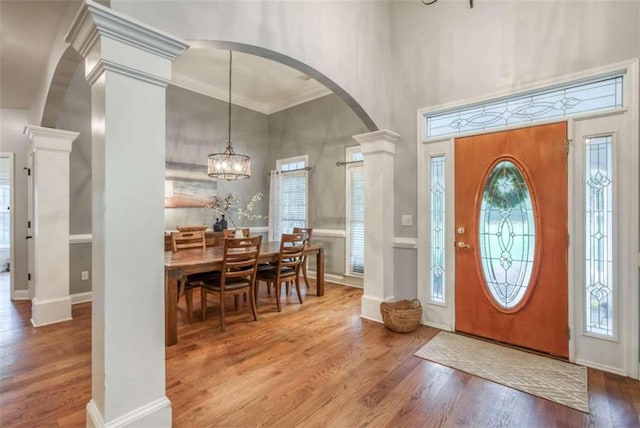 entryway with a chandelier, light wood-type flooring, and plenty of natural light