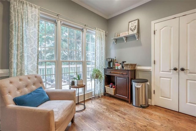 sitting room featuring crown molding and light hardwood / wood-style floors