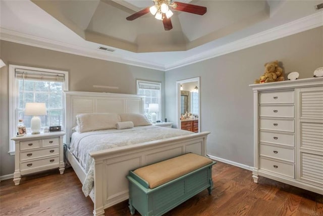 bedroom featuring ensuite bathroom, ceiling fan, ornamental molding, dark hardwood / wood-style floors, and a tray ceiling