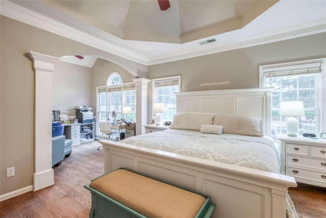 bedroom with ceiling fan, ornamental molding, ornate columns, and hardwood / wood-style floors