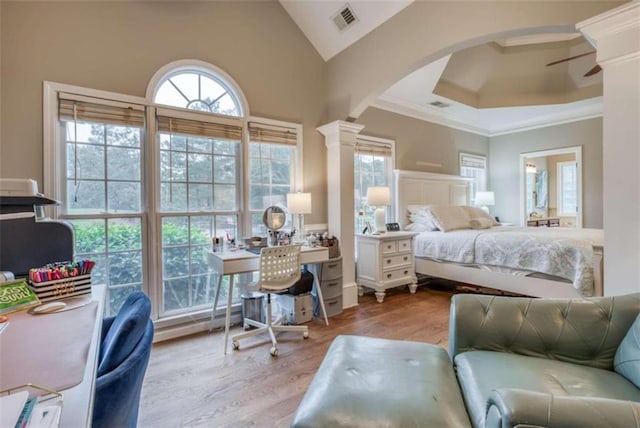 bedroom with multiple windows, light hardwood / wood-style flooring, and decorative columns