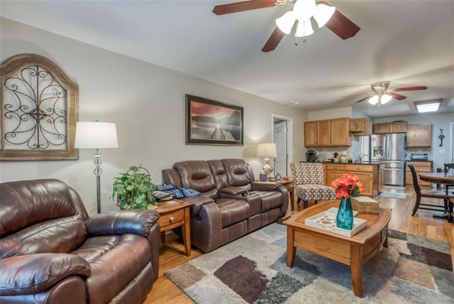 living room with ceiling fan and light hardwood / wood-style floors