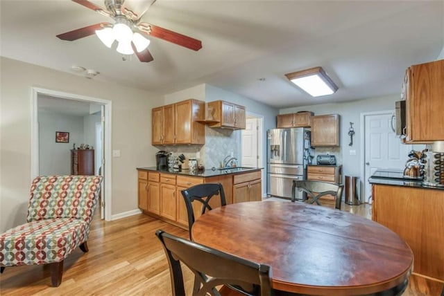 dining room with ceiling fan, sink, and light hardwood / wood-style floors