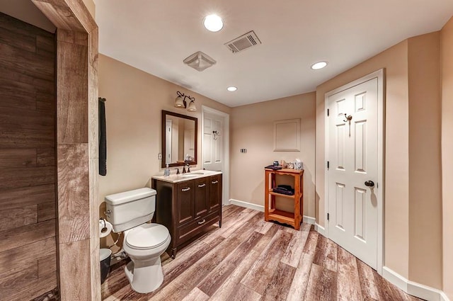 bathroom with hardwood / wood-style flooring, toilet, and vanity