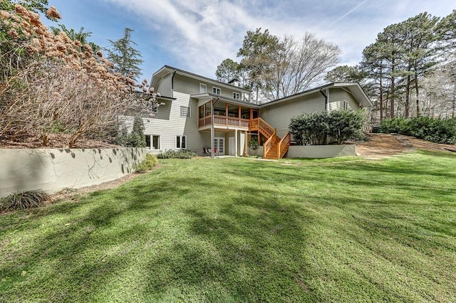 rear view of house with a deck and a yard