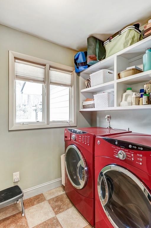 washroom featuring independent washer and dryer, light tile floors, and a wealth of natural light