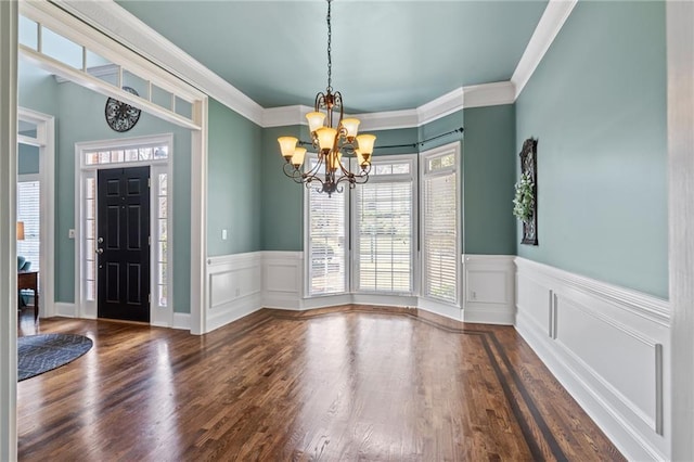 interior space featuring a notable chandelier, ornamental molding, and dark wood-type flooring