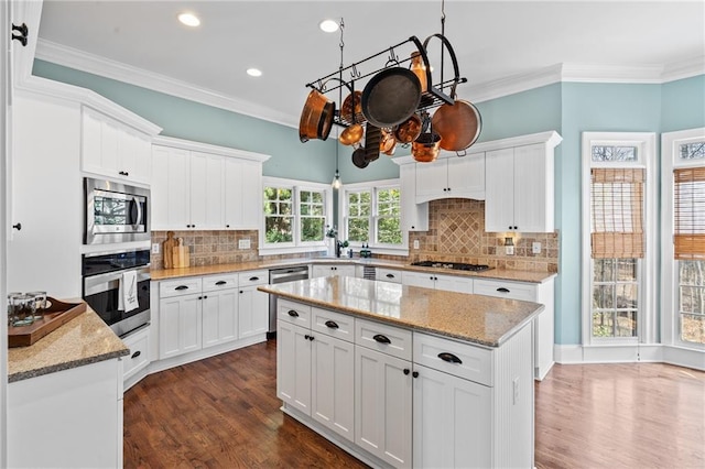 kitchen with white cabinets, backsplash, and appliances with stainless steel finishes