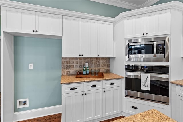 kitchen with white cabinetry, backsplash, and stainless steel appliances