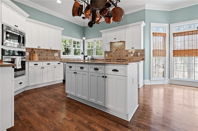 kitchen featuring backsplash, white cabinetry, dark hardwood / wood-style floors, and stainless steel appliances