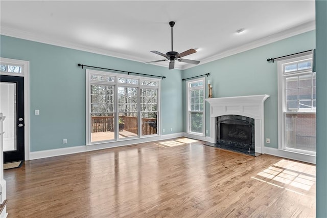 unfurnished living room featuring ceiling fan, a wealth of natural light, and light hardwood / wood-style floors