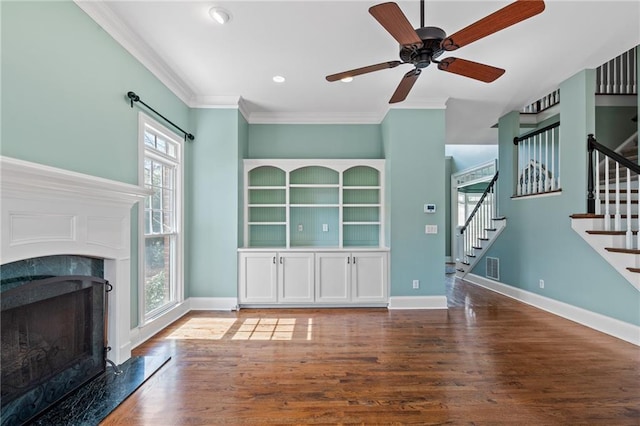 unfurnished living room featuring a healthy amount of sunlight, ceiling fan, dark hardwood / wood-style flooring, and ornamental molding