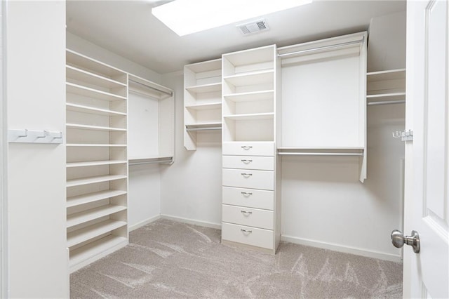 walk in closet featuring light colored carpet