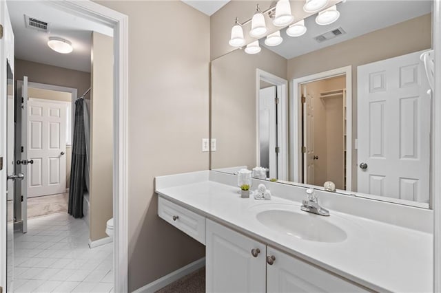 bathroom with tile flooring, vanity with extensive cabinet space, and toilet