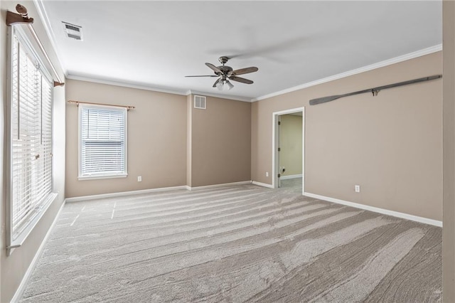 spare room with crown molding, light colored carpet, and ceiling fan