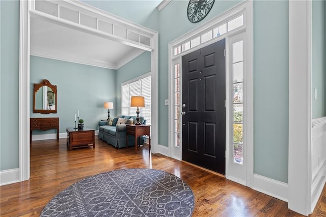 foyer featuring dark hardwood / wood-style flooring, a wealth of natural light, and ornamental molding