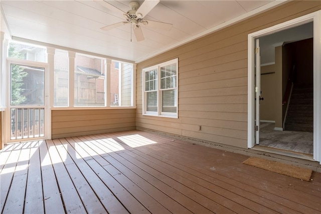 unfurnished sunroom featuring ceiling fan