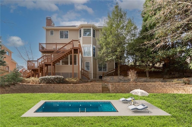 rear view of property with a patio, a swimming pool side deck, and a lawn