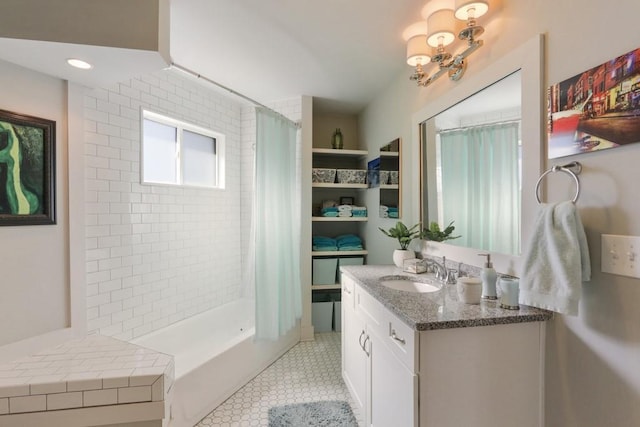 bathroom with an inviting chandelier, tile floors, and vanity with extensive cabinet space