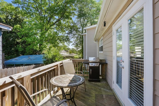 wooden balcony featuring grilling area and a wooden deck