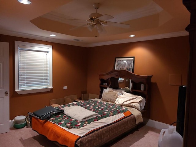 bedroom featuring light carpet, a tray ceiling, and ceiling fan