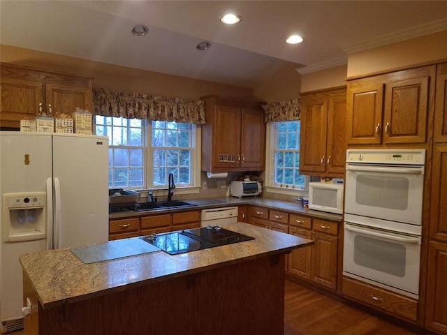 kitchen with white appliances, dark wood-type flooring, a center island, and plenty of natural light