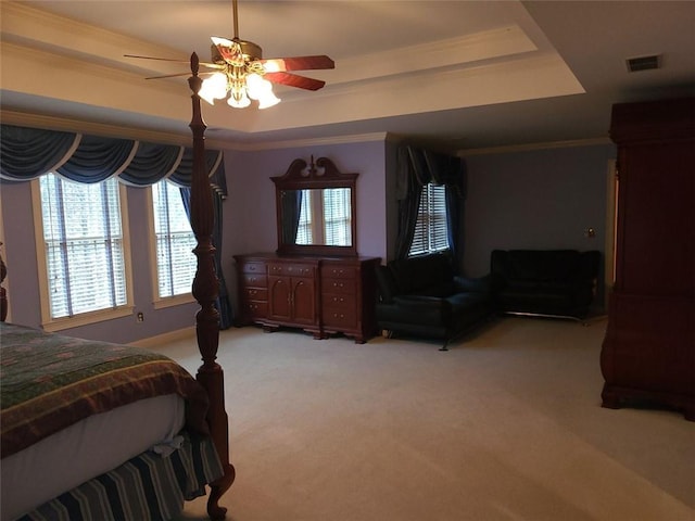 carpeted bedroom featuring ceiling fan and a tray ceiling