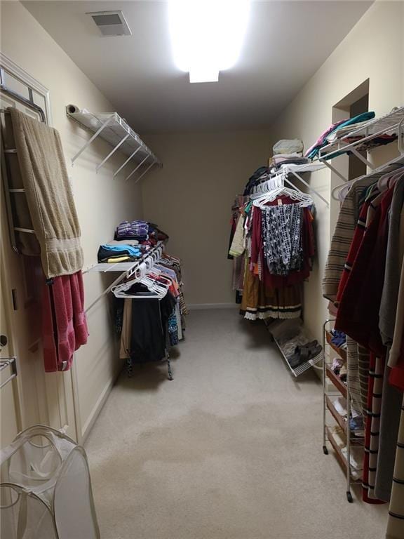 walk in closet featuring light carpet