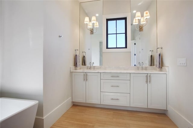 1068 Amsterdam Avenue Ne, Atlanta, GA 30306 - bathroom featuring dual sinks, large vanity, hardwood / wood-style floors, and a bath to relax in