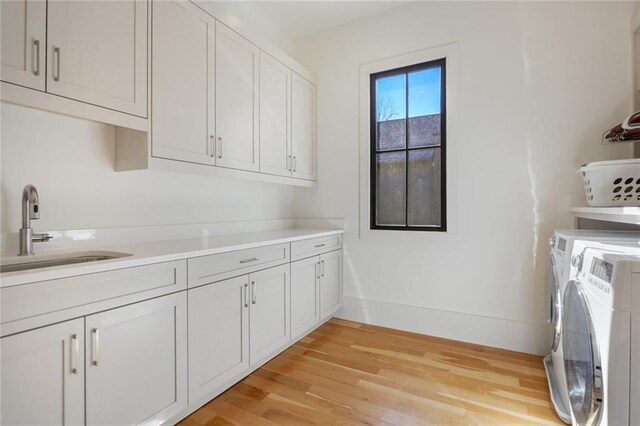 1068 Amsterdam Avenue Ne, Atlanta, GA 30306 - clothes washing area with washing machine and clothes dryer, cabinets, sink, and light wood-type flooring