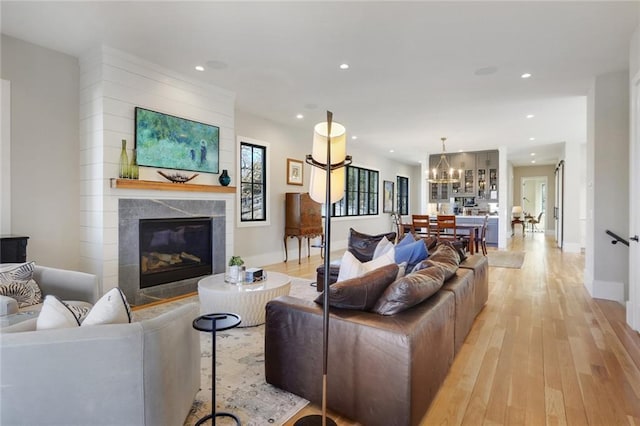 1068 Amsterdam Avenue Ne, Atlanta, GA 30306 - living room featuring a notable chandelier, a fireplace, and light hardwood / wood-style floors
